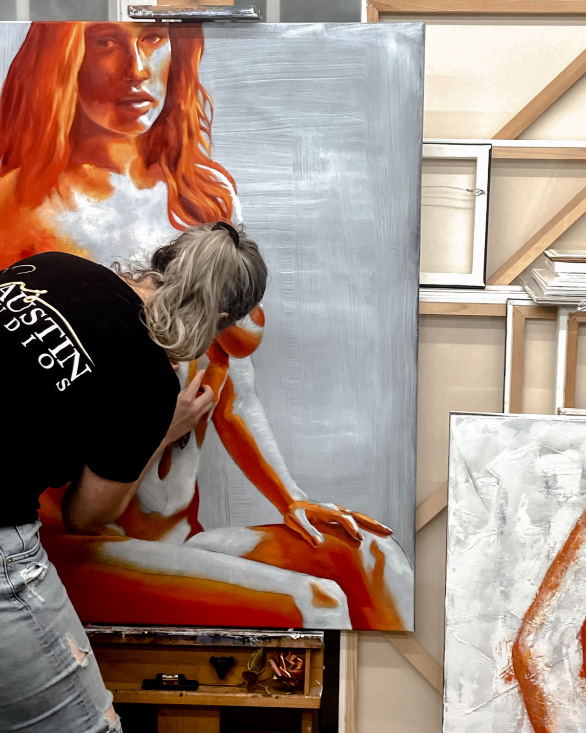In studio progress of original oil painting and mixed media by cassidy austin studios. orange pop-art textured nude woman in power stance. Titled: I Am Ascendant
