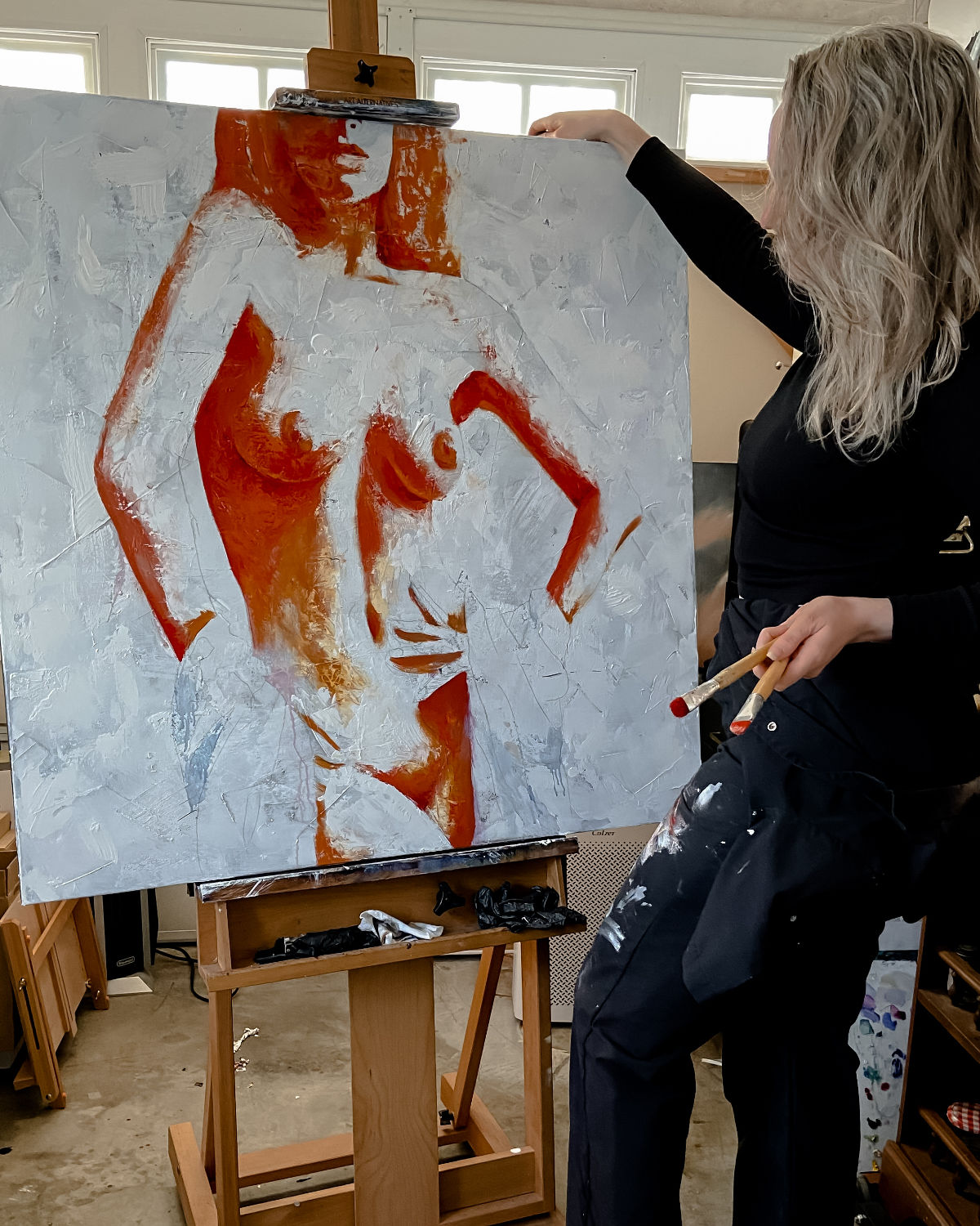 In studio progress of original oil painting and mixed media by cassidy austin studios. orange pop-art textured nude woman in power stance. Titled: I Am Power